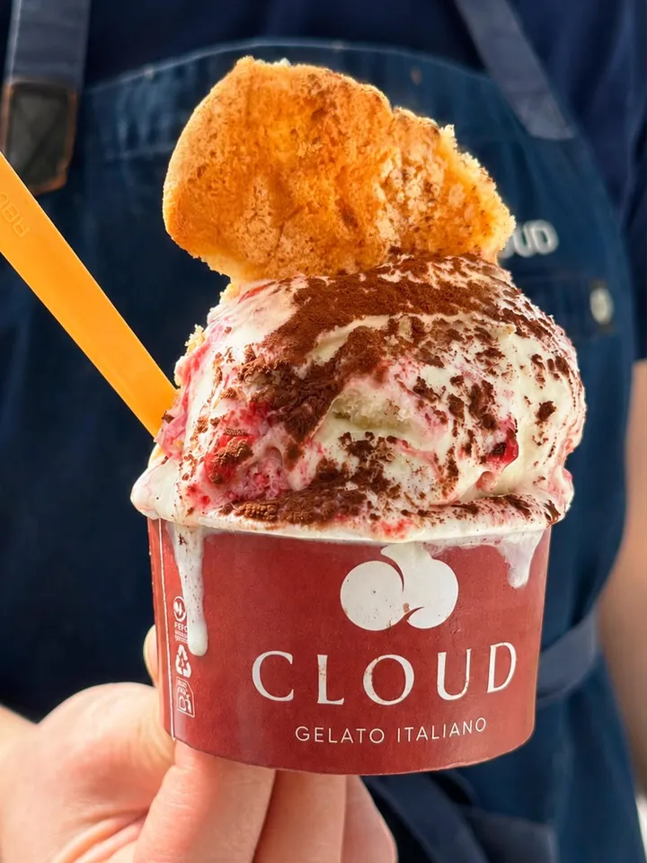 Tarrina de Cloud con gelato de tiramisú de fresa, coronada con un trozo de savoiardo
