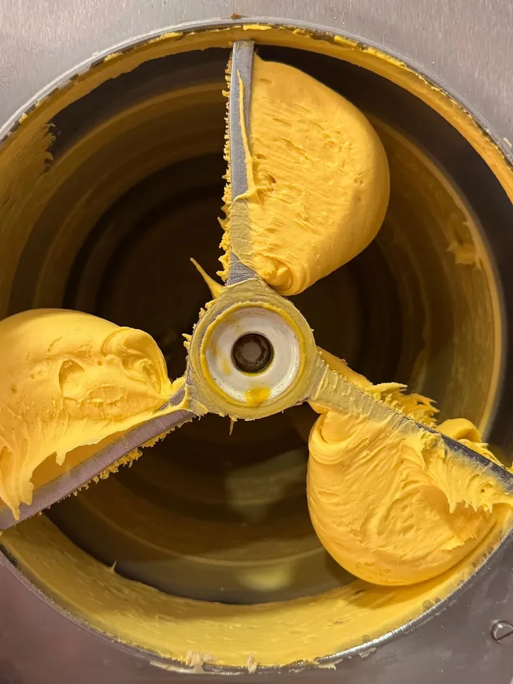 Gelato amarillo recién hecho en la mantecadora del obrador